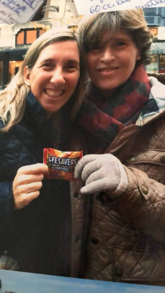dos mujeres sonriente lleva consigo abrigo y bufanda en sus manos un life savers