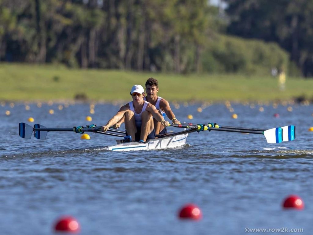 dos personas montados en un barco de remo en el mar